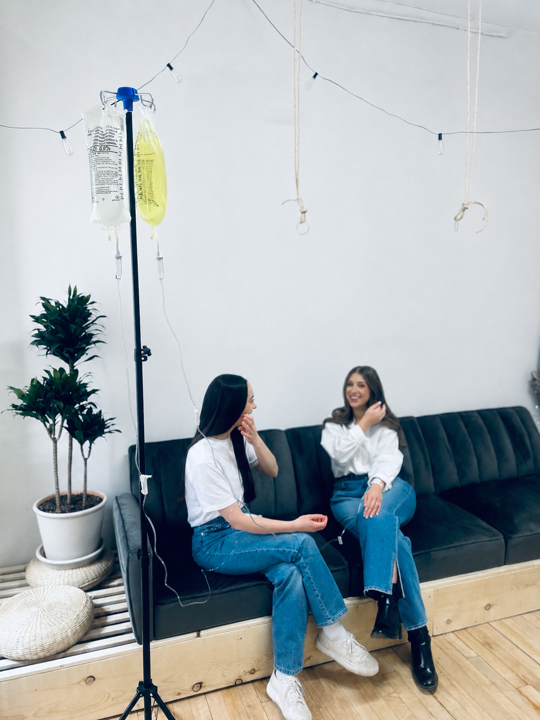 Two friends relaxing together during an IV therapy session at Northbound Wellness